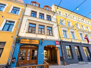 A building with a wooden door and a sign that reads 'HOLKRUUBS AALAPAGRABS'.