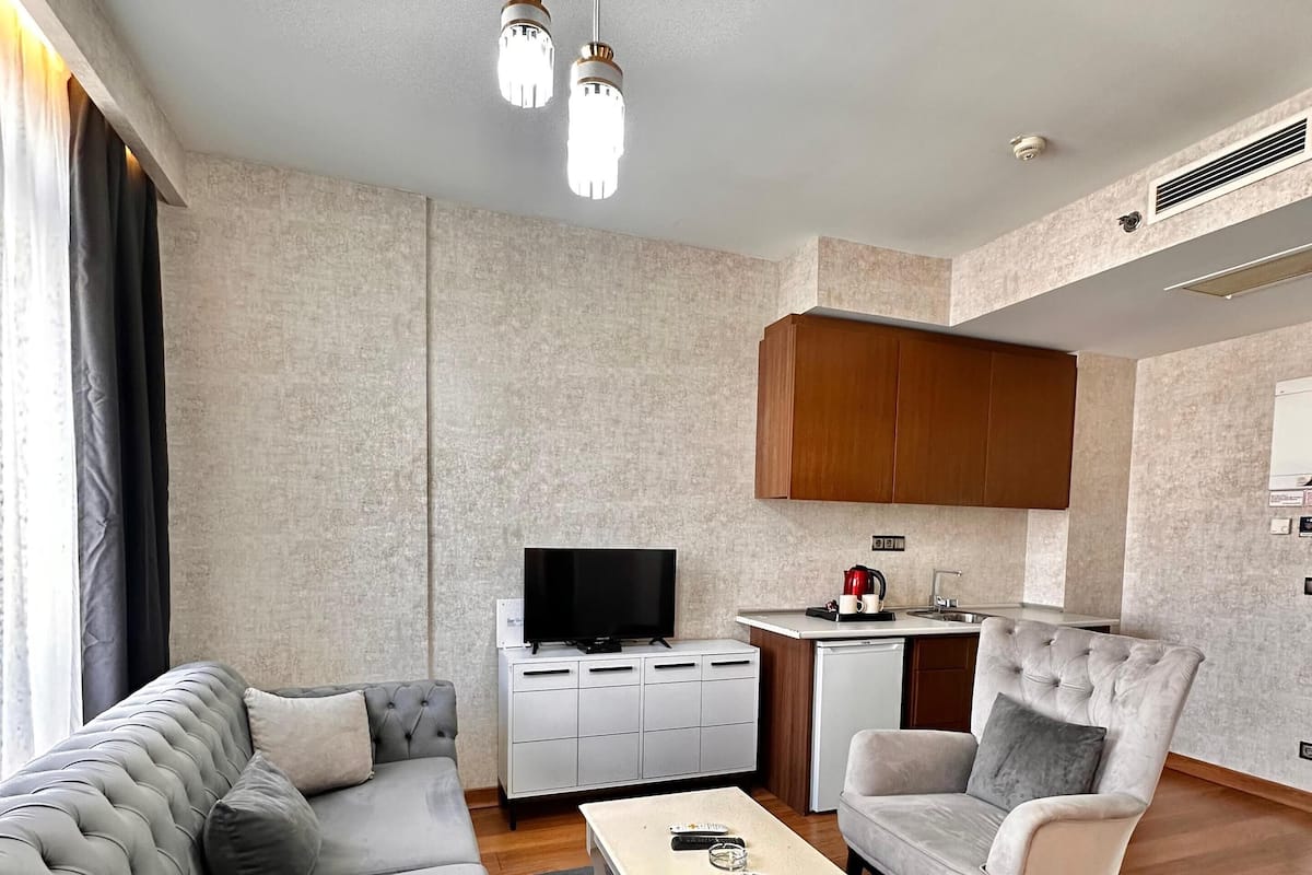 A modern living room with a grey sofa, a coffee table, and a television.