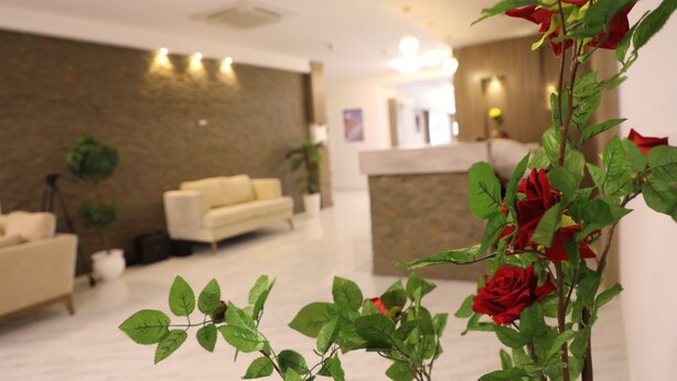 A modern hotel lobby with a reception desk, a sofa, and a potted plant. - Hotel Mizwar Djerba (Houmt Souk)