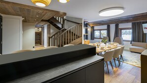 A modern kitchen with a central island, wooden flooring, and pendant lighting. - Beautiful apartment in Courchevel with parking 300m from slopes (Courchevel 1550)