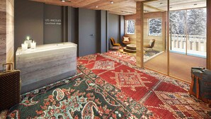 A hotel room with a wooden ceiling, a reception desk, a large window with a view of snow-covered trees, and a patterned carpet. - Beautiful apartment in Courchevel with parking 300m from slopes (Courchevel 1550)