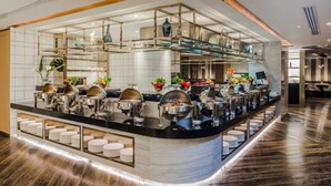 A buffet setup with multiple serving stations, a variety of dishes, and a modern interior design.