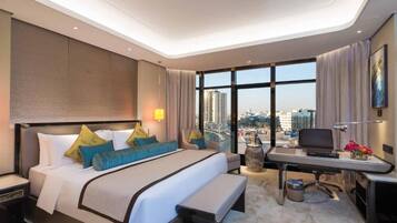 Habitación de hotel moderna con una cama grande, un escritorio y vistas a la ciudad.