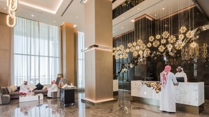 A modern lobby with a reception desk, seating area, and decorative lighting.