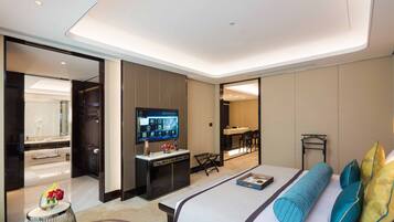 Una habitación de hotel moderna con una cama grande, un escritorio con televisor de pantalla plana, un baño con espejo y un área de comedor.