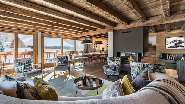 A spacious living area with a fireplace, wooden beams, and large windows overlooking a snowy landscape. - Modern chalet in Méribel, 5 bedrooms, jacuzzi, near cable car (Méribel)