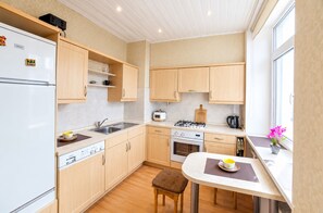 Une cuisine moderne avec des meubles en bois, un four encastré, une cuisinière à gaz et une fenêtre offrant une belle vue.