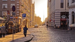 A cobblestone street in a European city with historic buildings, a café, and a Costa Coffee.