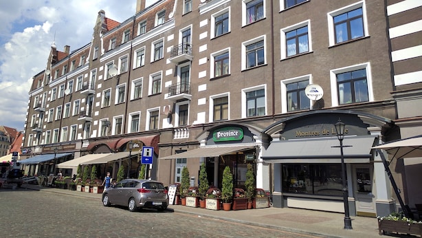 A row of traditional European buildings with shops on the ground floor.