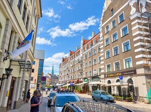 Une vue de rue avec des bâtiments, un drapeau et une enseigne « Golden Coffee ».