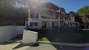 A two-story building with a balcony on the upper floor. - Lakefront Apartment with Private Garden and Secure Parking (Soorts-Hossegor)