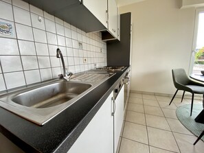 Appartement | Privékitchenette | Een koelkast met diepvriezer, een microgolfoven, een oven, een kookplaat