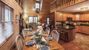L'intérieur d'une cabane en bois comprend un coin repas, une cuisine et un espace de vie.