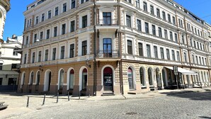 Un immeuble à plusieurs étages de style architectural classique, caractérisé par des fenêtres en arc et une façade symétrique.