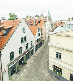 Una calle adoquinada flanqueada por edificios históricos, incluyendo un restaurante llamado 'Stazione Italiana'.