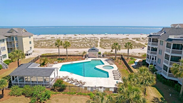 Ein Resort mit Schwimmbad, Blick auf den Strand und mehreren Gebäuden.