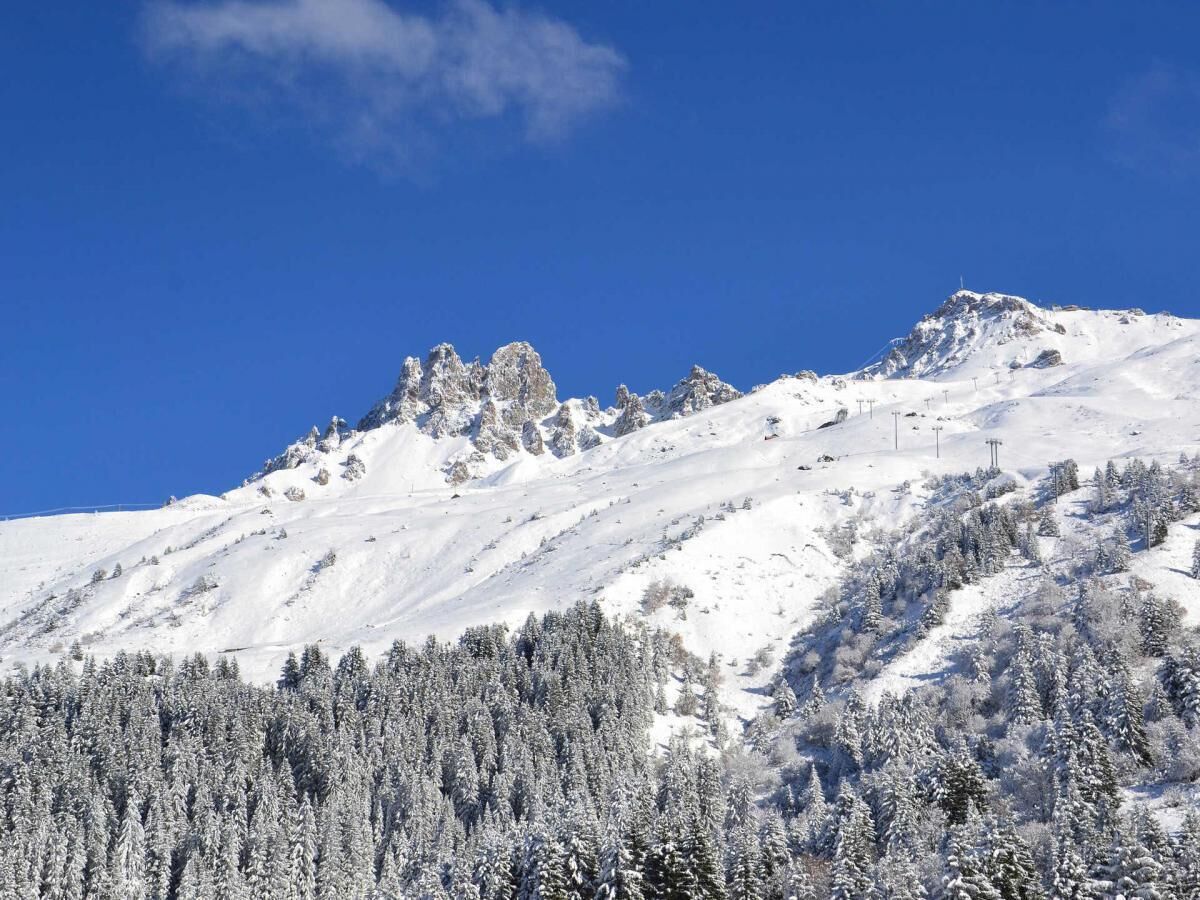 A snowy mountain landscape with a clear blue sky.