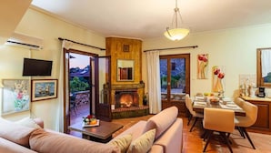 Ein gemütliches Wohnzimmer mit Kamin, Essbereich und einer Couch.