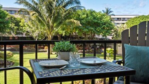 Mesa al aire libre con vista a un jardín exuberante y un edificio en el fondo.