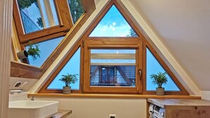 Un baño moderno con tragaluz, tocador de madera y lavadora.