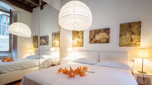 Ein Hotelzimmer mit zwei Betten, einem großen Spiegel und Bildern an den Wänden.