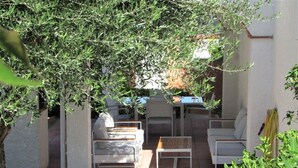 En udendørs patio med en sofasæt, et bord og en stol.