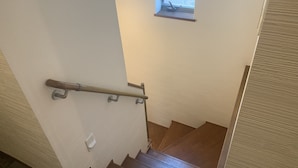 A staircase with a handrail, a window, and a door. - B&B Yuigahama (Kamakura)