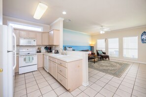 Enjoy cooking in this well-equipped kitchen with a central island, microwave, oven, and sink, and dine in the adjacent dining area with a table and chairs.