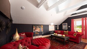 Un salon avec un canapé rouge, une table basse et un tapis à motifs.