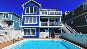 Un bâtiment à deux étages doté d’une piscine, d’un balcon et d’un escalier.