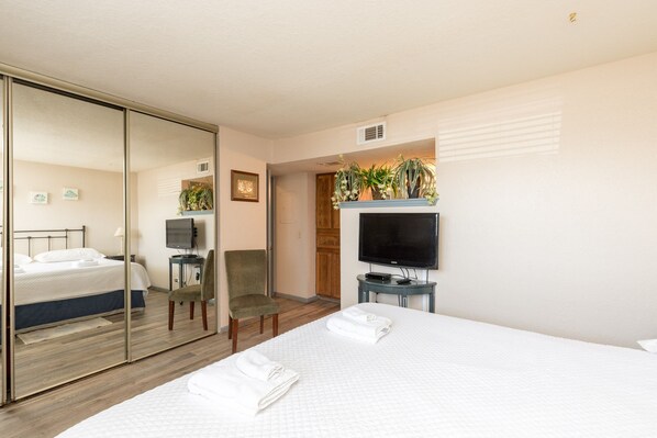A hotel room with a bed, a chair, a TV, and a mirror. - First-Floor Waterfront Escape | Pool & Fishing Dock Access (CORPUS CHRISTI)