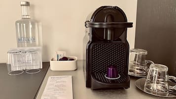 A coffee machine, a bottle of water, and a menu on a table.