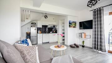 Een koelkast, een magnetron, kookgerei, borden en bestek