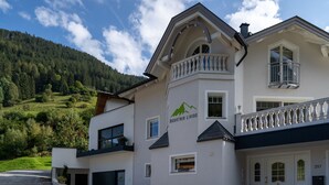 A two-story building with a balcony, a mountain logo, and the number 297. - Mountain Living Apartments - Ski-In & Ski-Out (See)