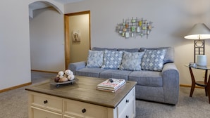 Un salon avec un canapé, une table basse et une lampe.