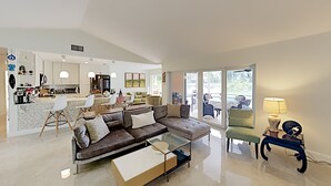 A spacious living area with a modern sofa, a glass coffee table, and a view of the outdoors through large sliding doors. - Make yourself at home in Delray Beach!!<br><br><br> (Delray Beach)