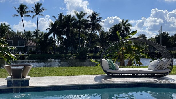 A pool with a water feature, a lounge chair, and palm trees in the background. - Make yourself at home in Delray Beach!!<br><br><br> (Delray Beach)