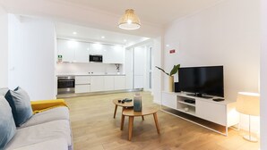 A modern living room with a sofa, a TV, and a dining table.