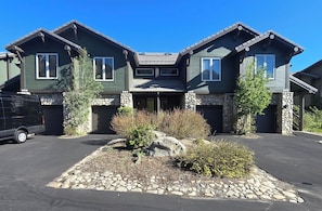 A two-story house with a stone foundation and a driveway. - Snowcreek Resort Vacation Rental 988 (Mammoth Lakes)
