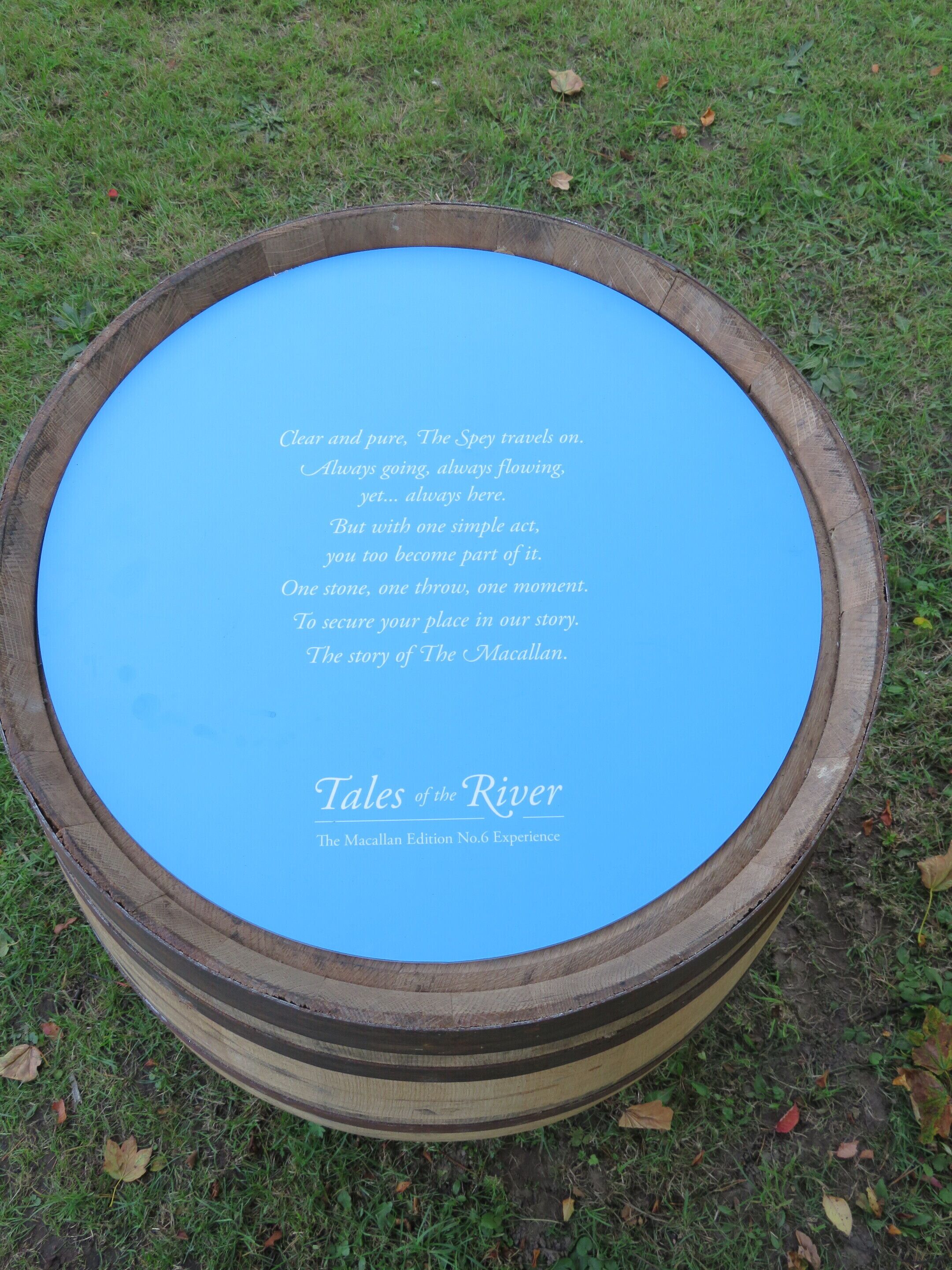 Un barril de madera con interior azul, grabado con texto y el título "Tales of the River - The Macallan Edition No.6 Experience".