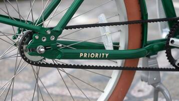 Un primo piano della ruota posteriore e della catena di una bicicletta, con la scritta 'PRIORITY' sul telaio.