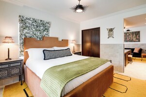 Une chambre bien rangée, avec un grand lit, des tables de chevet, un bureau et une chaise.