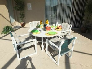 Enjoy dining al fresco in this outdoor space, featuring a round table and comfortable seating for four.