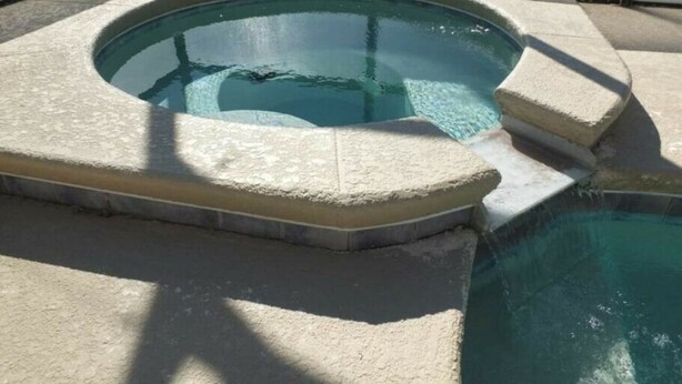 Ein Whirlpool mit Steinverkleidung und einem klaren Pool.