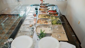 En buffet med forskellige retter og serveringsbestik.