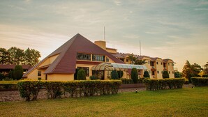 Et stort, flerlags hotel med et markant trekantet tag og et overdækket udendørs område.