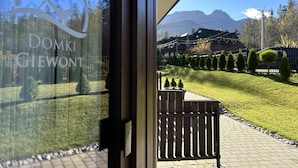 A view from a window with a sign reading "DOMKI GIEWONT" reflecting a mountain landscape. - Apartamenty Domki Giewont (Zakopane)