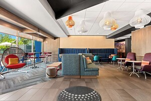 A modern lounge area with seating arrangements, a sofa, and hanging pendant lights.