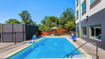 Een seizoensgebonden buitenzwembad, parasols voor strand/zwembad