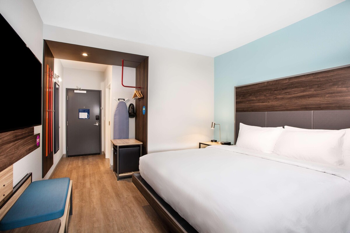 Une chambre d’hôtel avec un grand lit, une télévision, un bureau et une chaise.